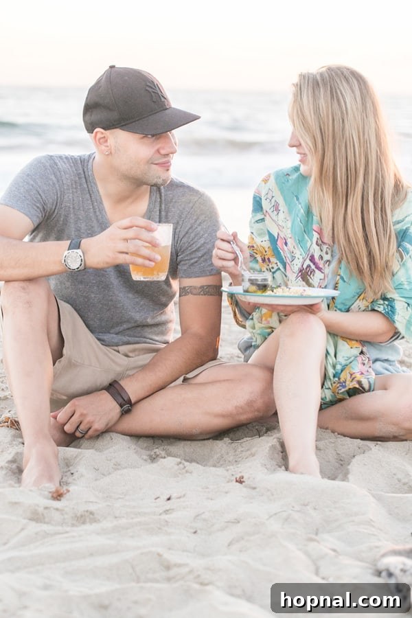 Crafting Your Dream Beach Bonfire Night 9 A couple relaxing on blankets on the beach, enjoying food and the bonfire.
