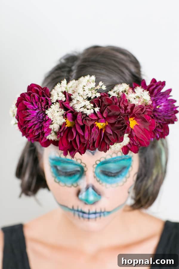 Effortless Día de los Muertos Makeup & DIY Flower Crown Guide 8 Model looking down thoughtfully, wearing a Day of the Dead floral crown and artistic makeup