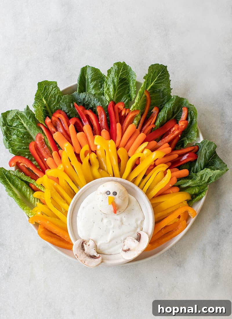 Little Gobblers' Thanksgiving Table 16 A festive kids' vegetable platter for Thanksgiving, creatively shaped like a turkey with a variety of colorful vegetables and a dip.