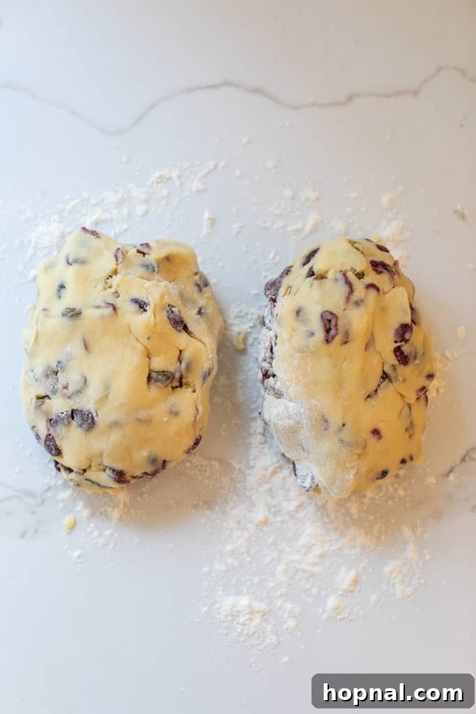 Jeweled Cranberry Pistachio Biscotti 9 Formed biscotti dough logs with cranberries and pistachios on a baking sheet.
