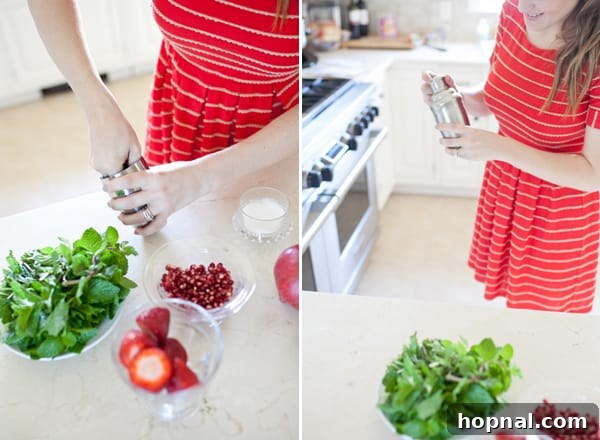 Fresh mint leaves, ripe strawberries, and a whole pomegranate laid out, ready for making delicious mojitos.