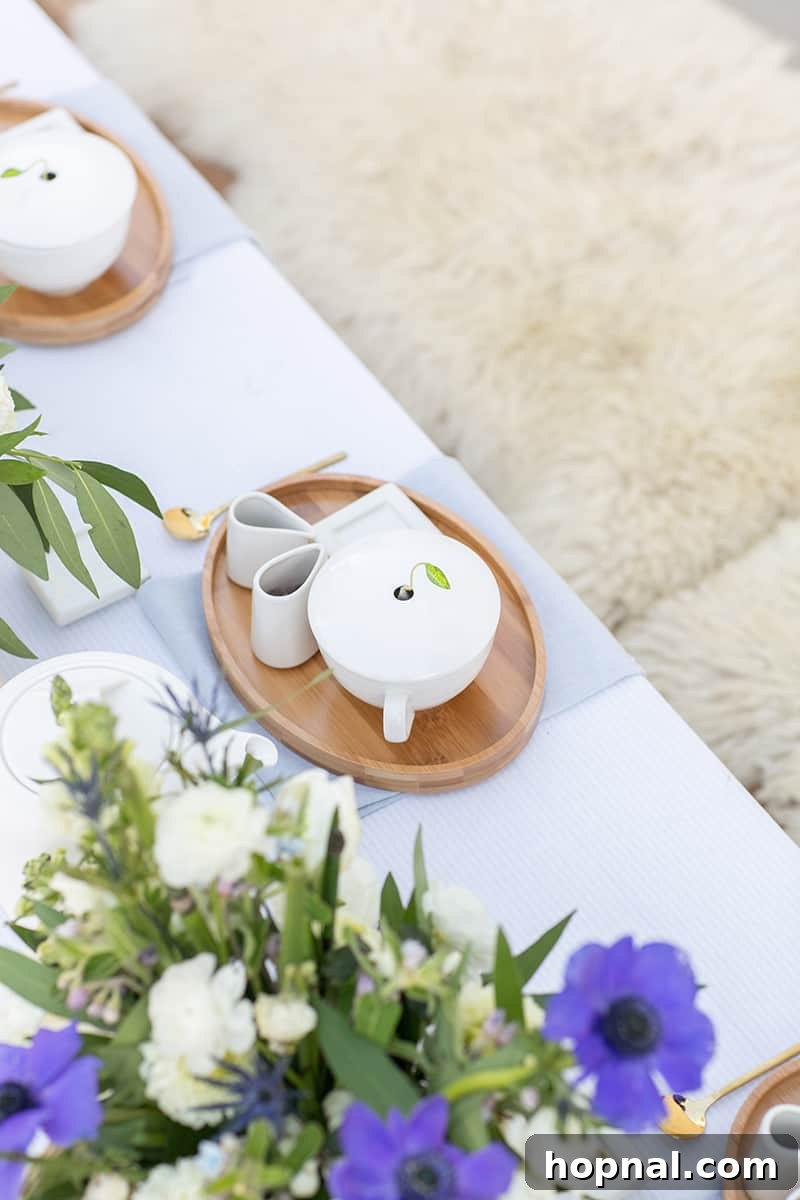 An elegant tea setting featuring blue and white flowers and table linens, with a focus on loose leaf tea for brewing.