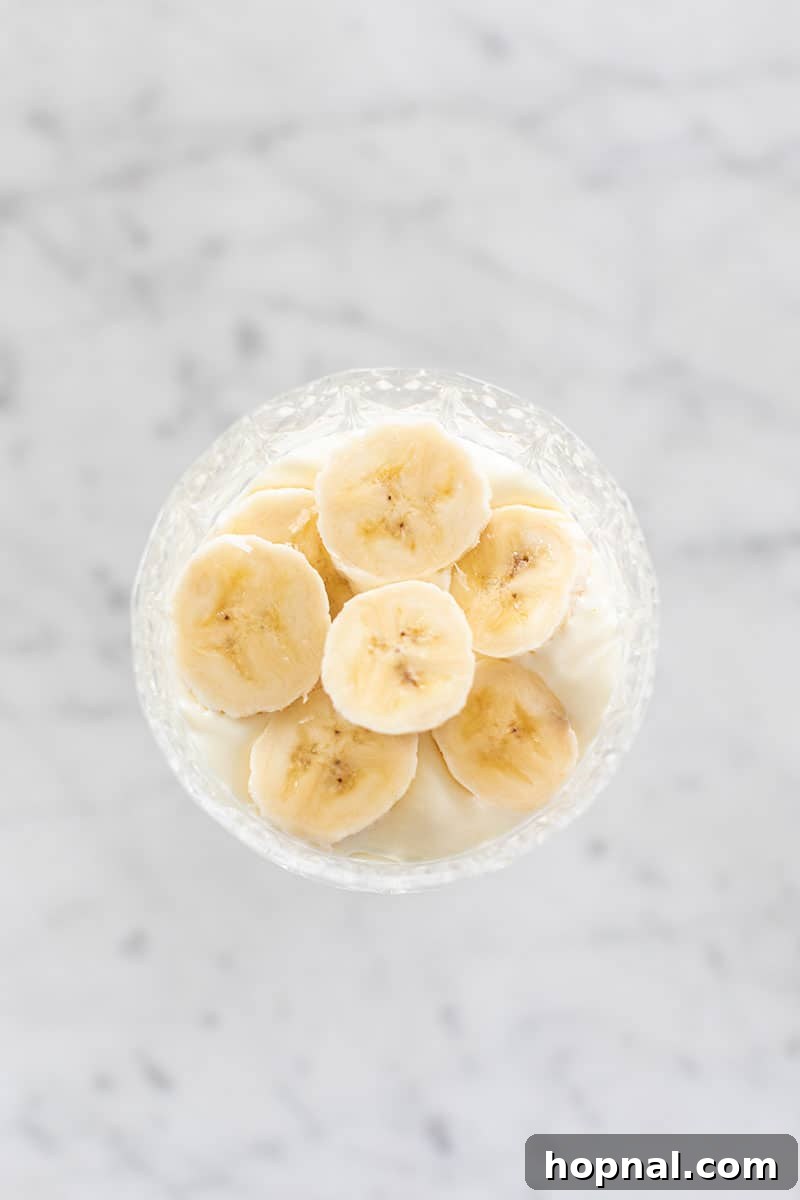 Heavenly Banana Pudding 12 A layer of fresh banana slices artfully arranged over a layer of banana pudding, ready for the next layer.
