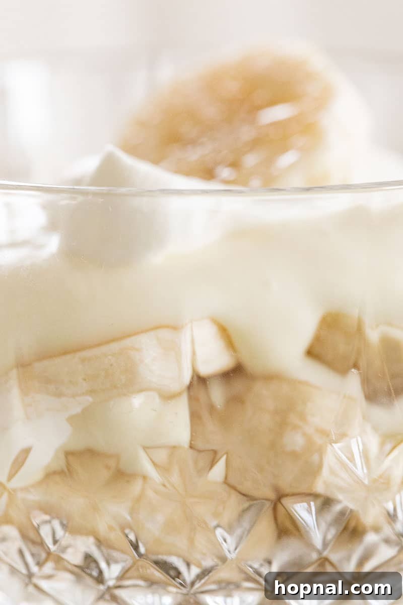 Heavenly Banana Pudding 13 An assembled banana pudding, showcasing visible layers of creamy pudding and sliced bananas in a clear glass.