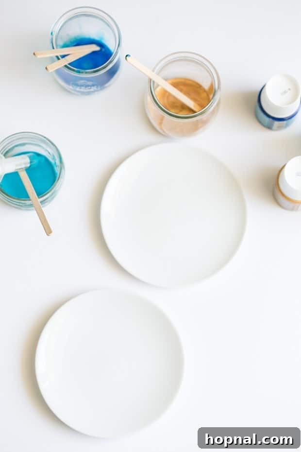 White plate ready for painting, with various colored paints in small jars