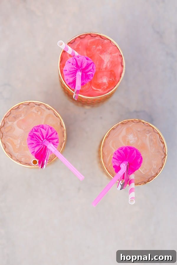 Three colorful cocktails adorned with flamingo straws, ready for a pool party