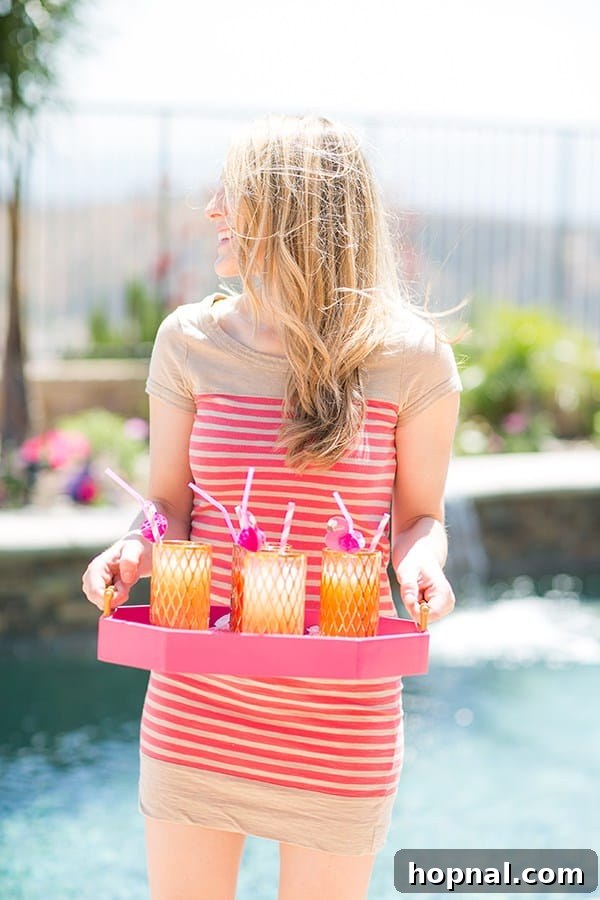 Eden Passante holding a tray of cocktails at a flamingo pool party, dressed for summer