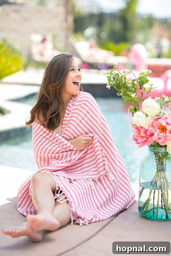 Girl with a pink striped towel wrapped around her, ready for fun at a pool party