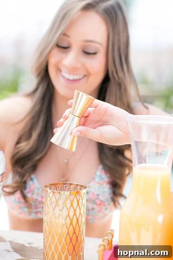 Two cocktails, one with a flamingo straw, on a tray at a flamingo pool party