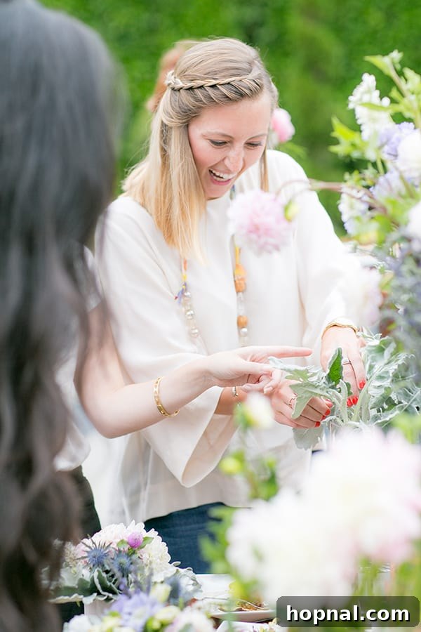 A guest proudly holding a beautiful and unique floral arrangement she created herself at the White Fig Designs station.