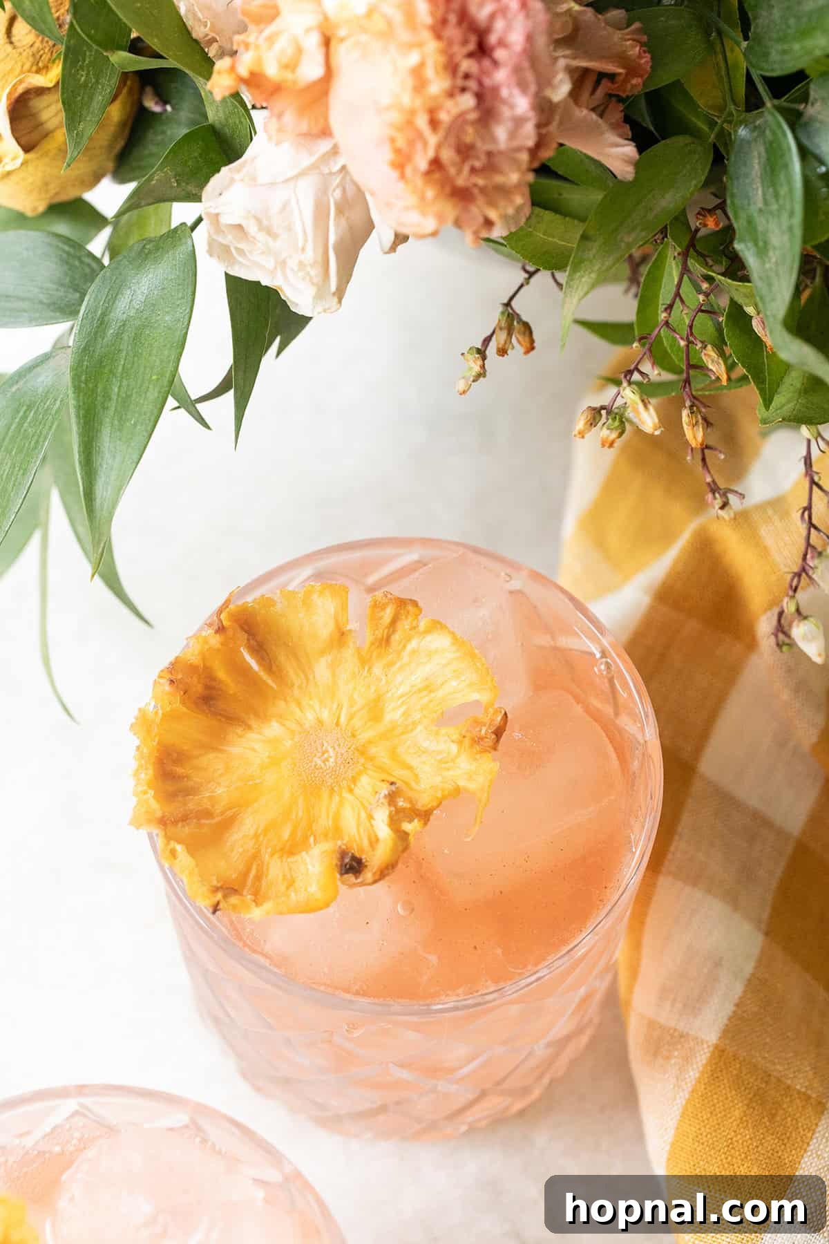 A vibrant pineapple flower elegantly garnishing a refreshing drink, adding a tropical touch.
