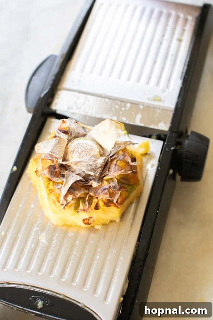 A sharp knife meticulously slicing thin rounds of pineapple, preparing them for dehydration.