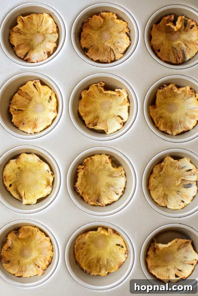Dried pineapple slices gently pressed into a muffin tin to achieve their signature flower shape.