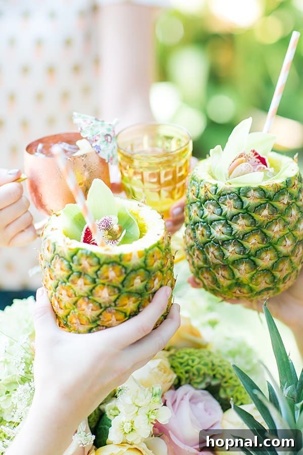 Group of ladies raising their pineapple cocktails in a toast, celebrating joyfully.