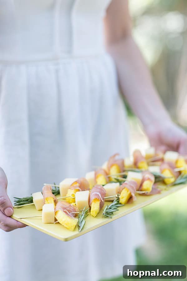 Delicious pineapple wrapped in prosciutto, beautifully presented on a vibrant yellow plate.
