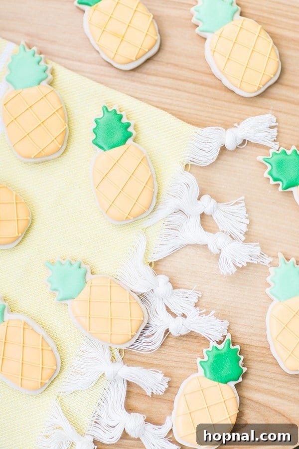 A collection of beautifully decorated pineapple sugar cookies arranged on a table, ready to be enjoyed.