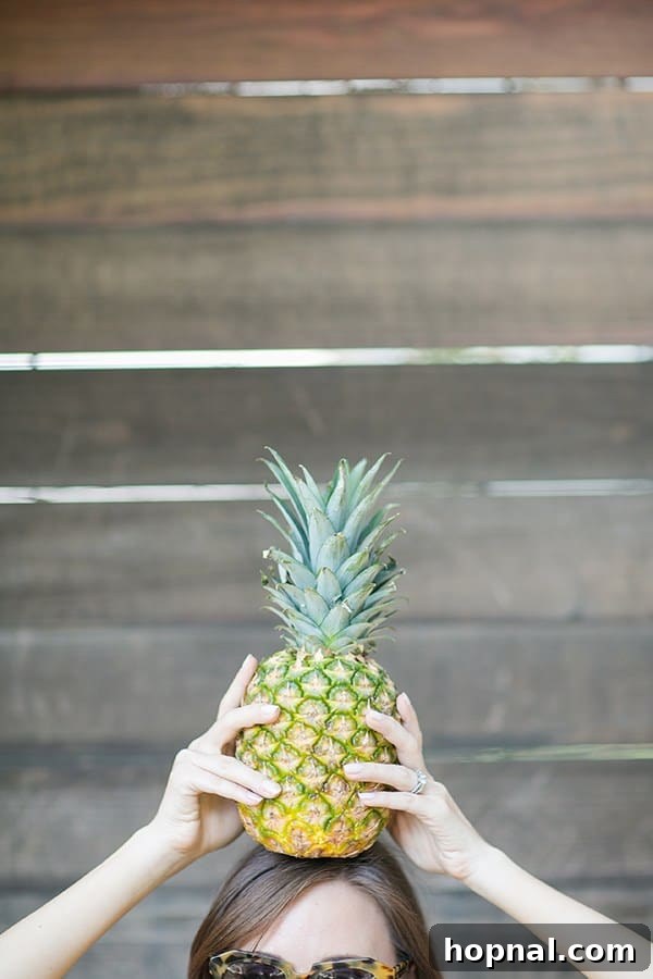 A playful image of a girl balancing a fresh pineapple on her head, adding a touch of whimsy.