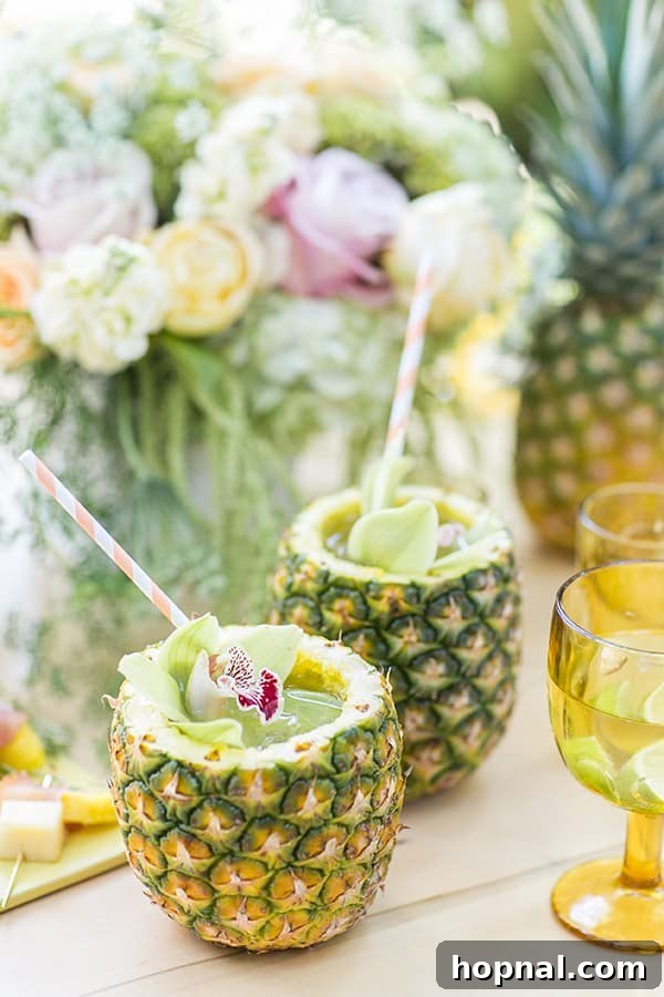 Two vibrant pineapple mojitos beautifully arranged on a table next to a yellow glass, exuding tropical charm.
