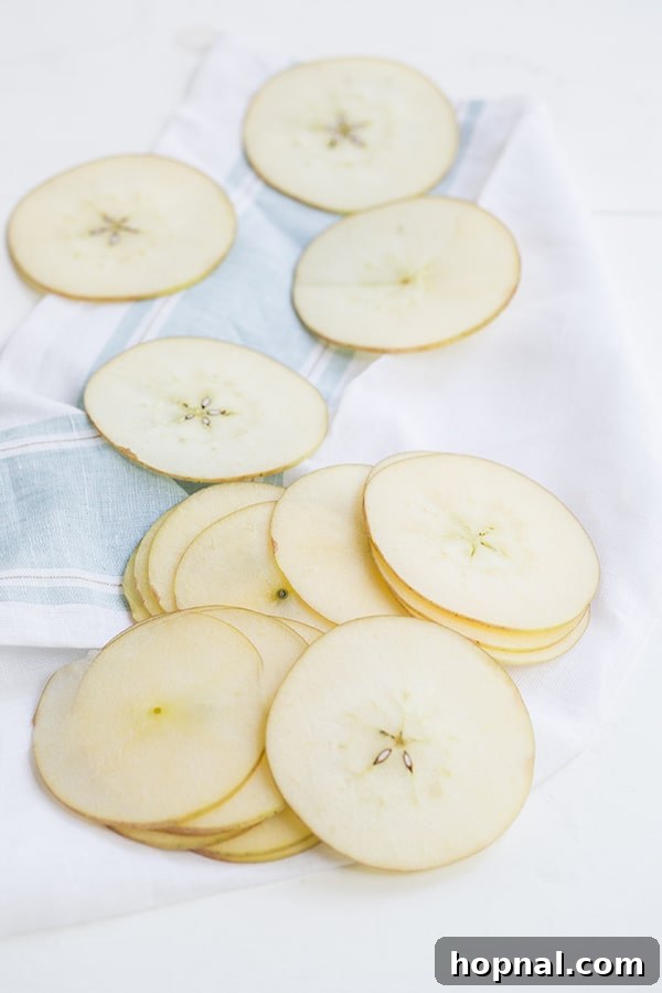 Close-up of freshly sliced pears, showing their delicate texture and uniform thickness, perfectly prepared for baking into crispy chips.