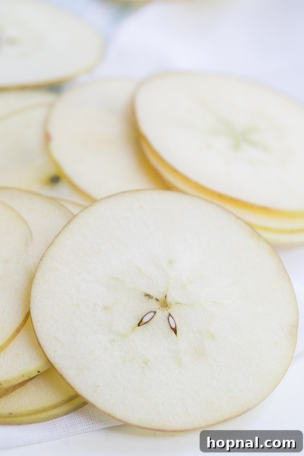 Detailed close-up shot of thinly sliced pears, perfectly prepared and evenly spaced for the homemade chip recipe.