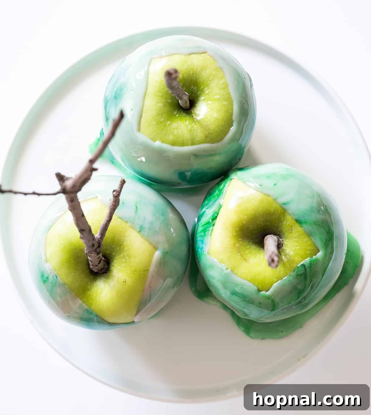 A selection of Halloween-themed candy apples, featuring a stunning marbled candy coating in various spooky colors, artfully displayed.