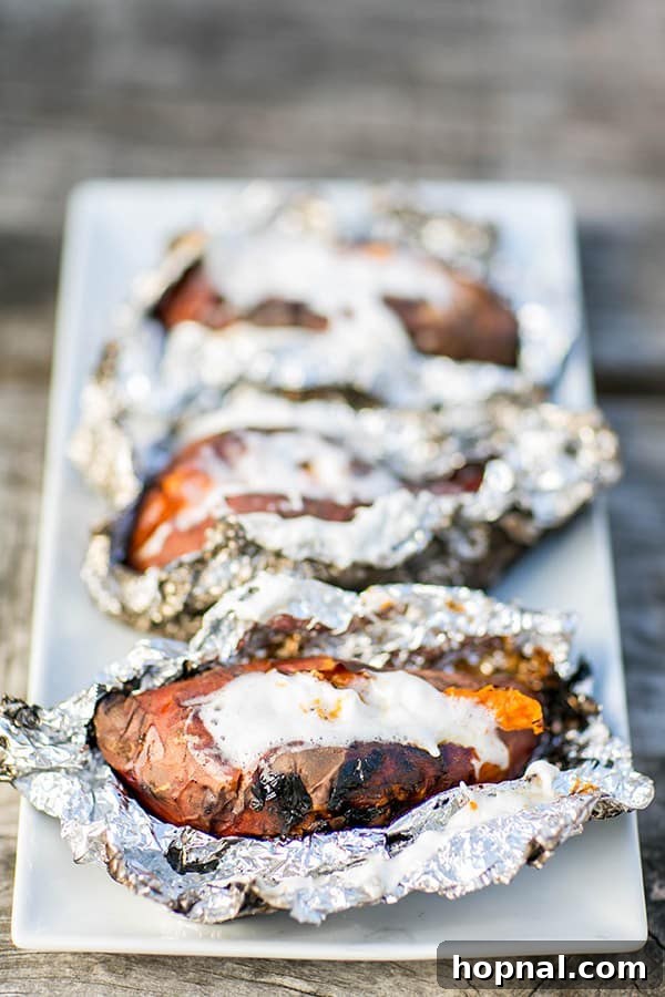 Sweet potatoes wrapped in tin foil, ready to be cooked over a camp stove for a Thanksgiving camping meal.