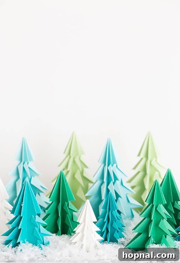 Paper origami trees on a table with fake snow. - A charming DIY origami Christmas tree craft for holiday decor.