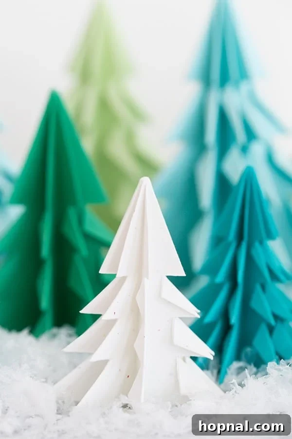 Paper origami trees on a table with fake snow. - A beautiful winter themed table decor with paper trees.