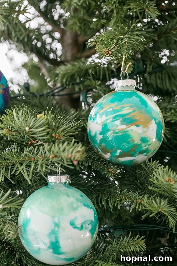 Marbled baubles hanging on a decorated Christmas tree