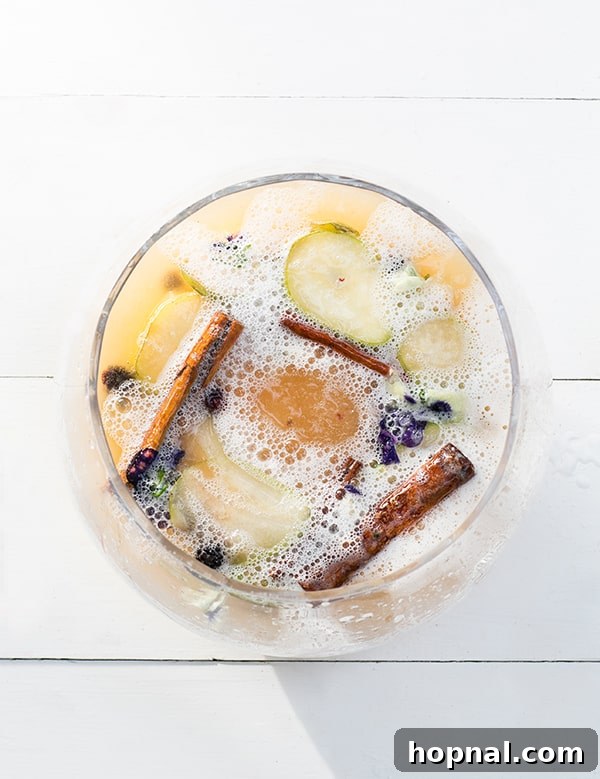 Top-down shot of a sparkling peach cocktail in a glass, garnished with fresh fruit