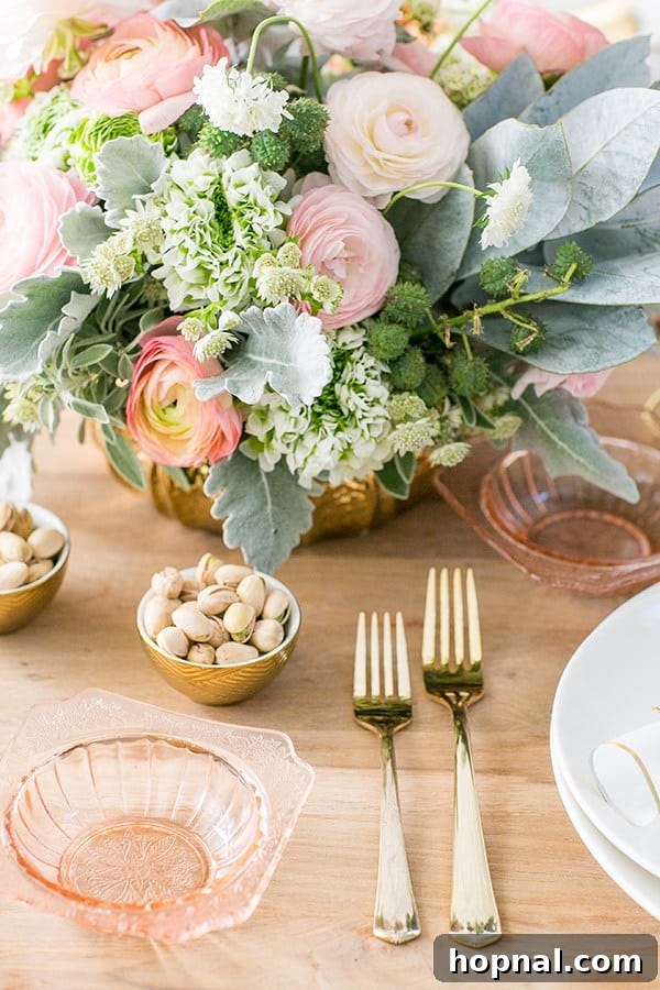 Close-up of elegant gold flatware and a vibrant floral arrangement on a New Year's Eve table setting.