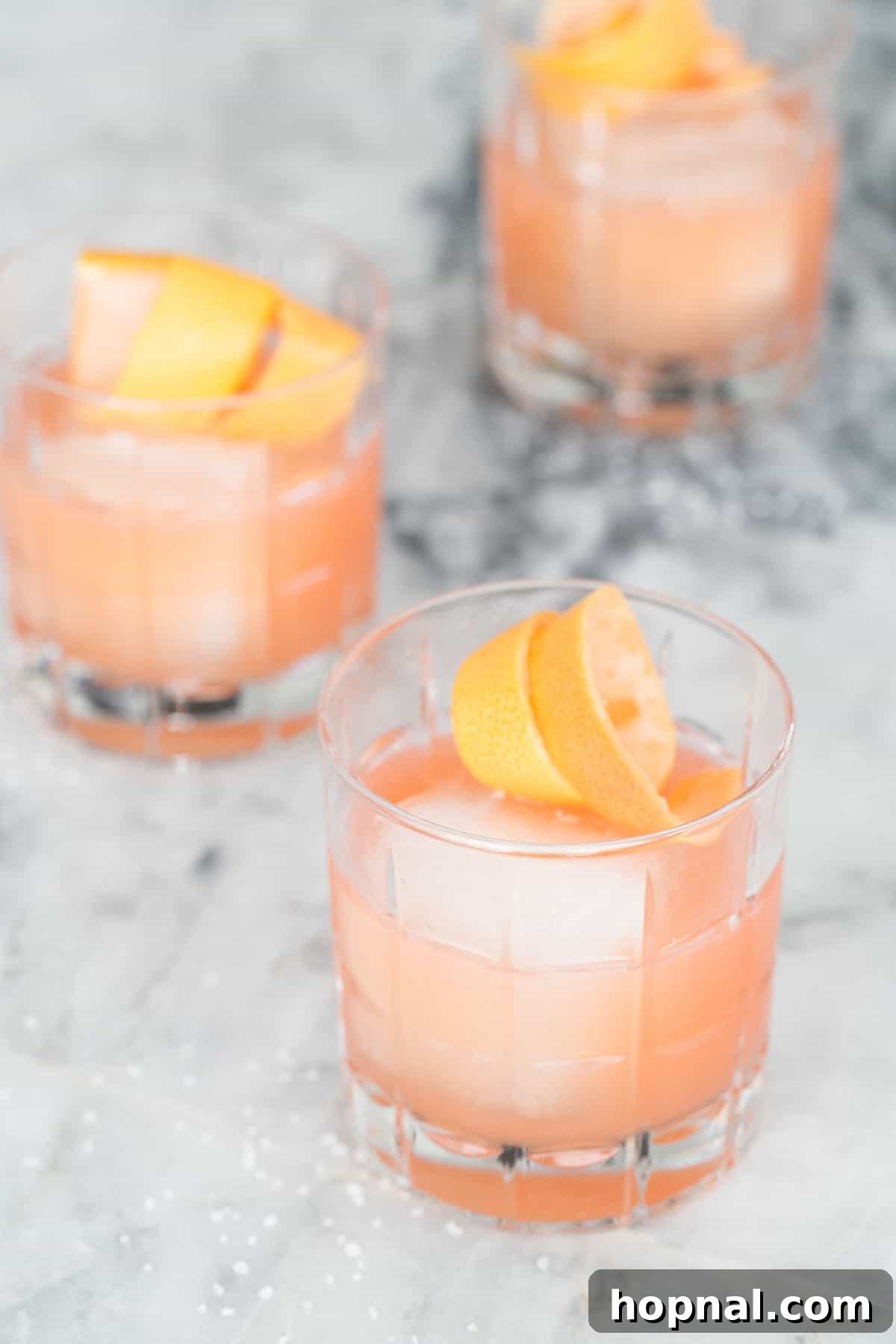 Italian Paloma Spritz 5 Three Italian Paloma cocktails garnished with orange slices and grapefruit wedges, ready for serving.