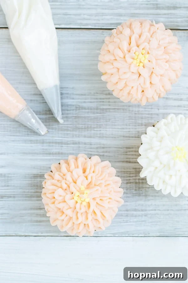 Overhead shot of two frosted floral cupcakes - vanilla frosting