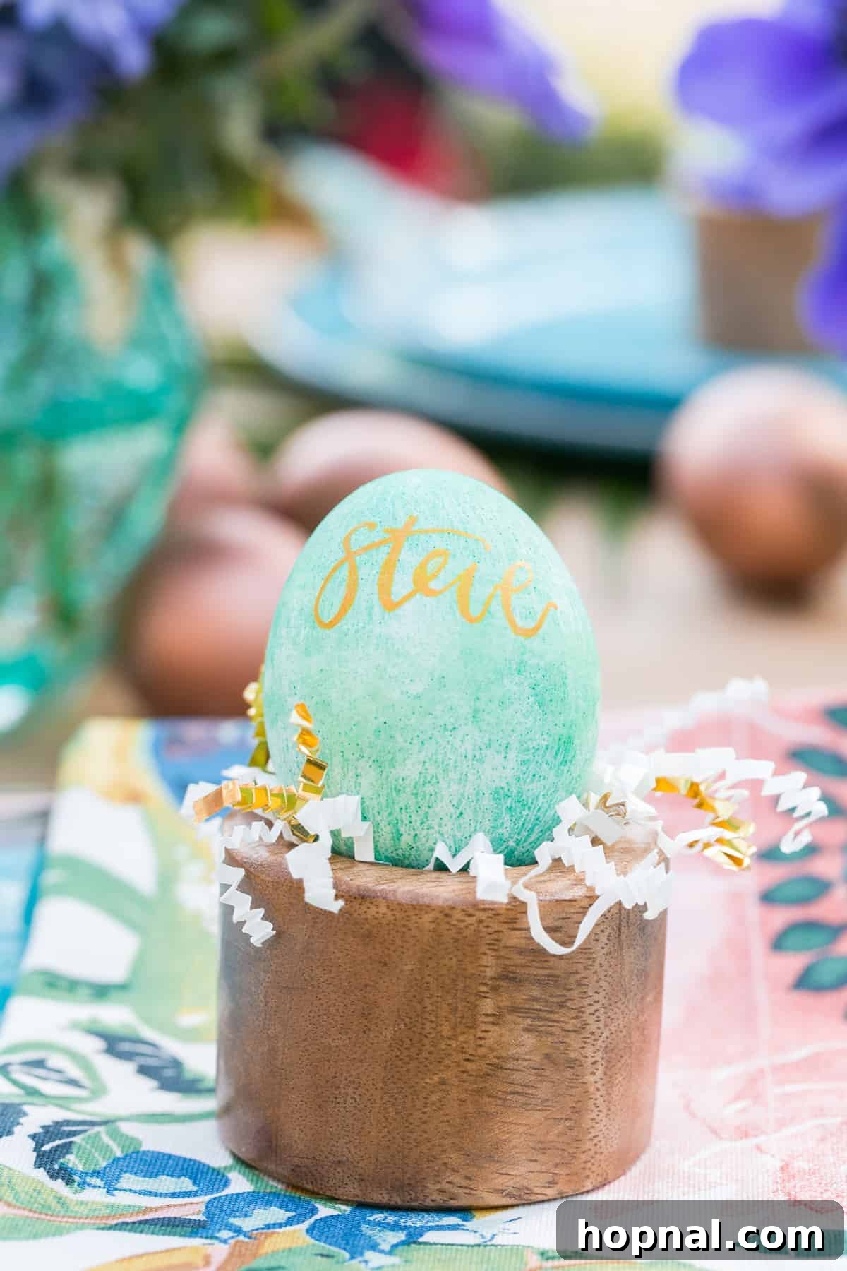 Calligraphy Easter eggs serving as unique place cards on a vibrant Moroccan-themed table setting, adding a personal touch to the Easter brunch.