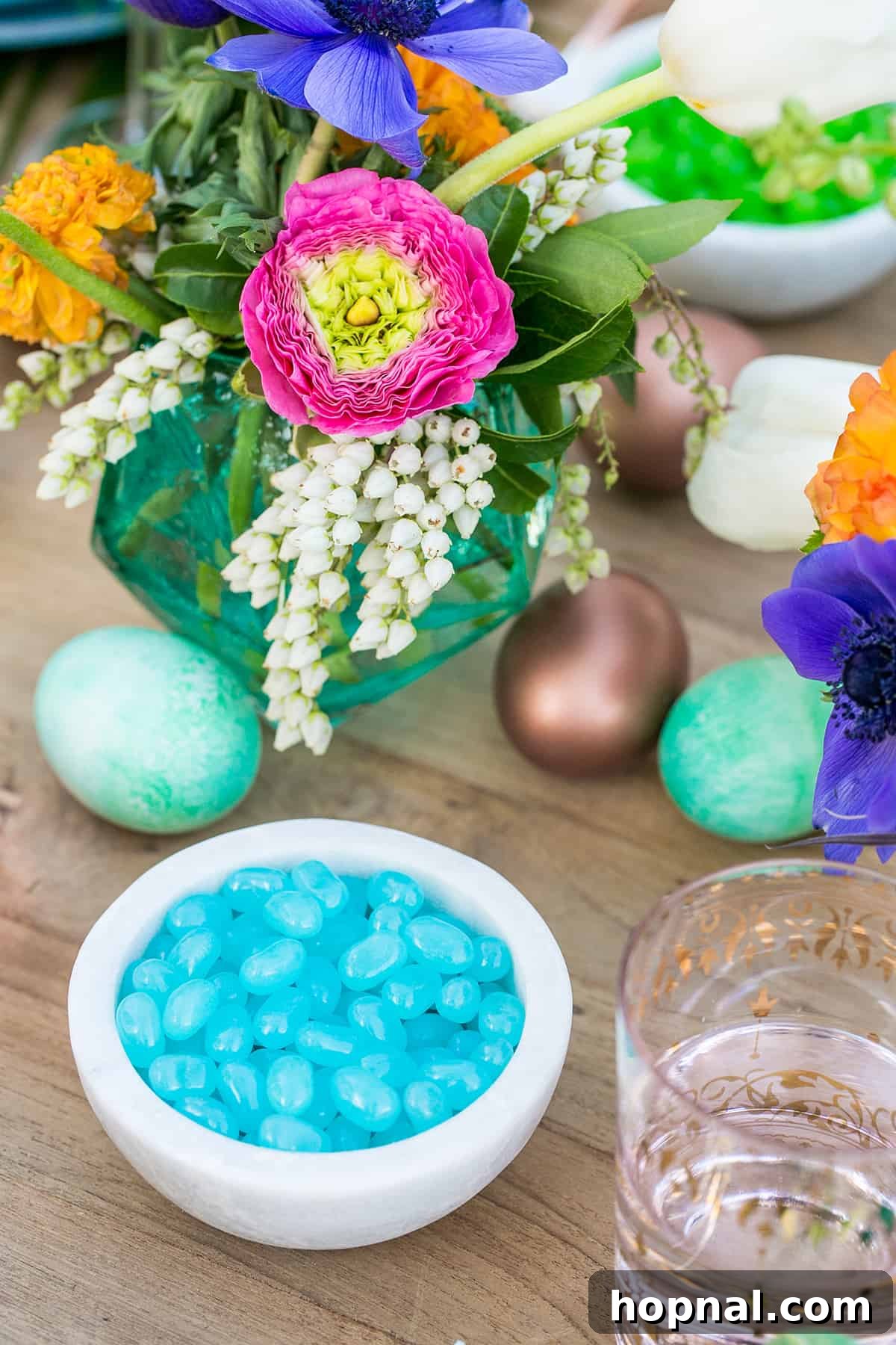 Blue jelly beans and flowers accent a colorful Easter table, showcasing more creative party ideas and vibrant decorations.