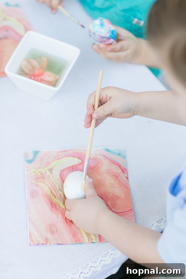 Dyeing for Easter Fun 19 A toddler's tiny hands delicately painting an Easter egg, capturing the pure joy and concentration of a simple creative activity.