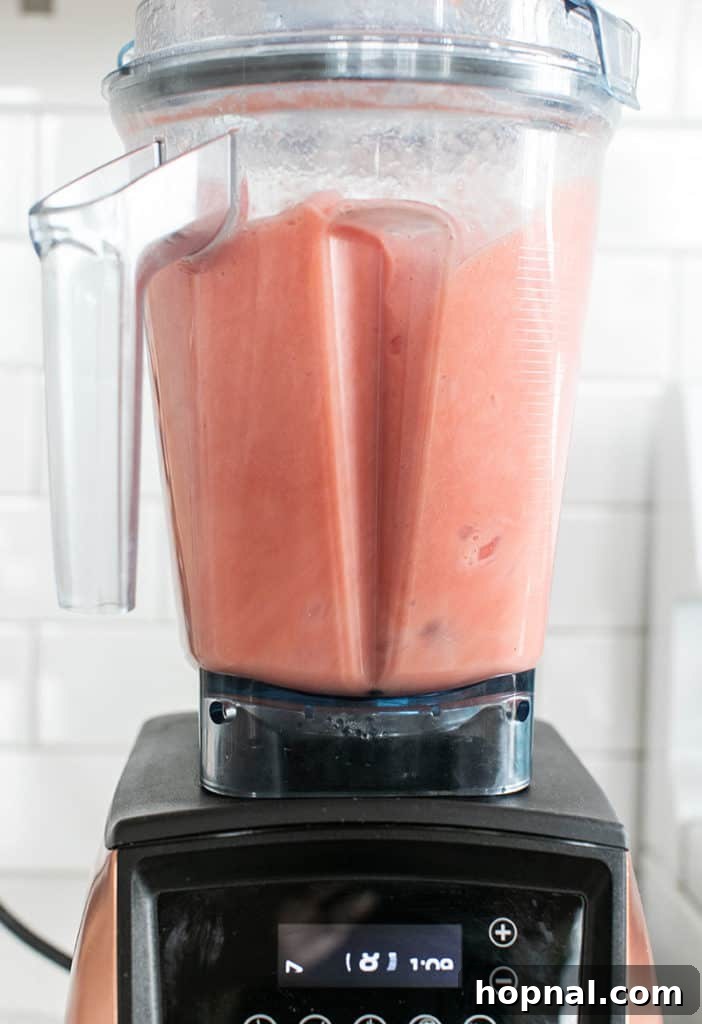 Cool Watermelon Quencher 5 Watermelon blending smoothly in a blender, transforming into a frothy, bright pink liquid.