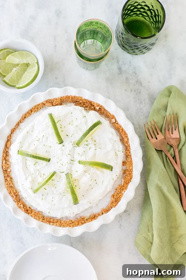 Zesty Island Dream Pie 2 A stunning Key Lime Pie topped with generous whipped cream and garnished with fresh lime slices, set on a rustic wooden table.