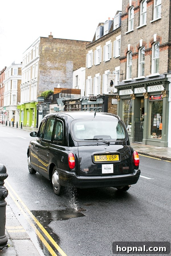 A charming London black taxi driving on a street