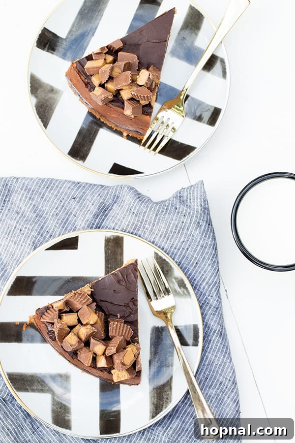 Close-up of a slice of chocolate peanut butter cheesecake showing distinct layers and topping