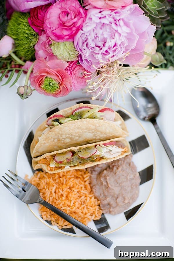 Spice Up Your Cinco de Mayo Celebration 6 Tacos, rice and beans on a black and white plate.