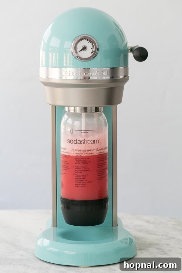 A KitchenAid Sparkling Beverage Maker on a kitchen counter, ready for use.