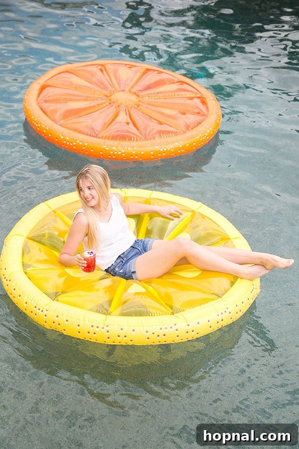 Girl floating on a lemon slice pol float at a pool party 