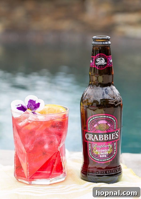 Crabbies ginger beer with a pink cocktail next to it 