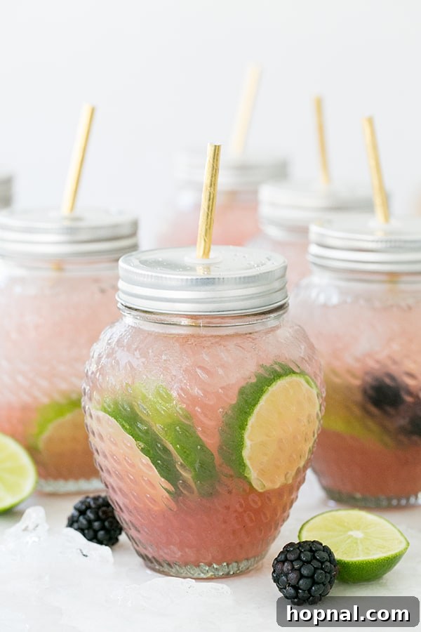 shot of blackberry margarita in a glass jar - lime wedge