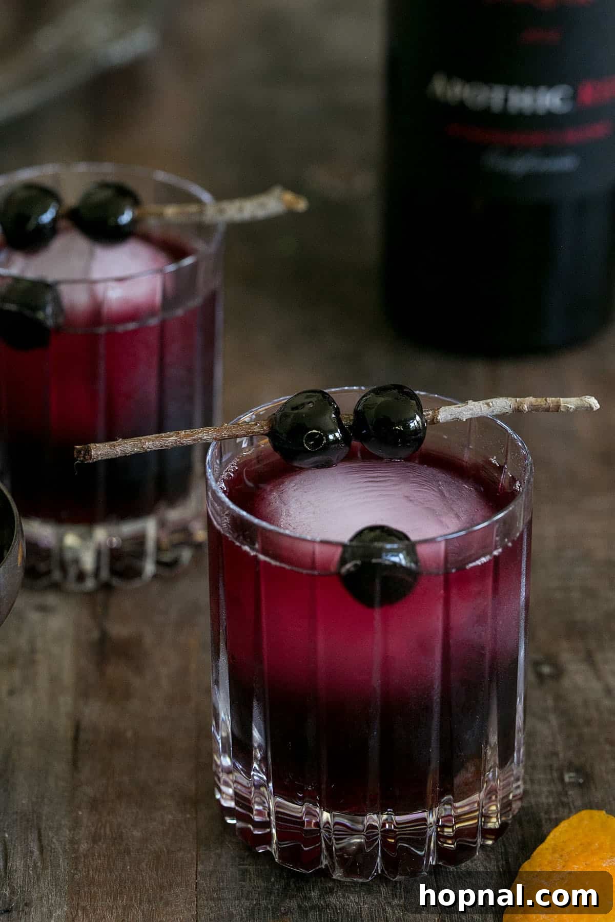 Crimson Moon Manhattan 2 Red Moon Over Manhattan red wine cocktail with an orange peel garnish, set against a dark background