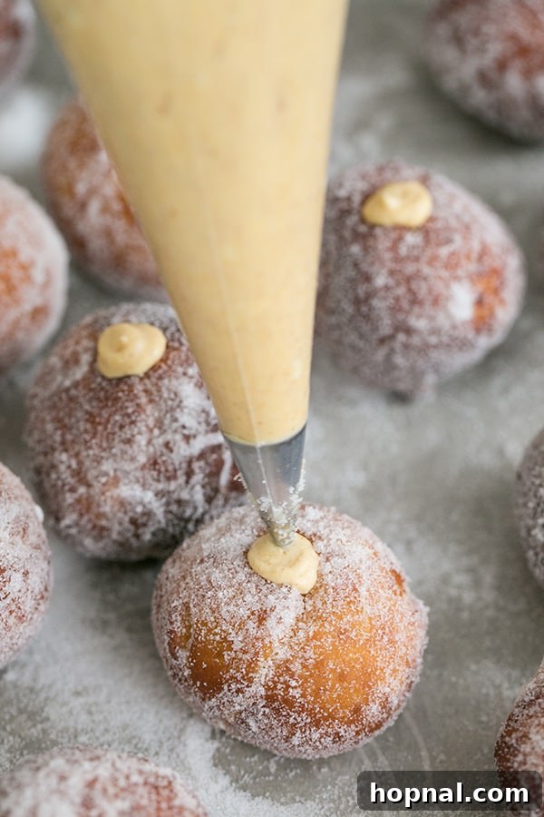 shot of homemade donut holes being filled