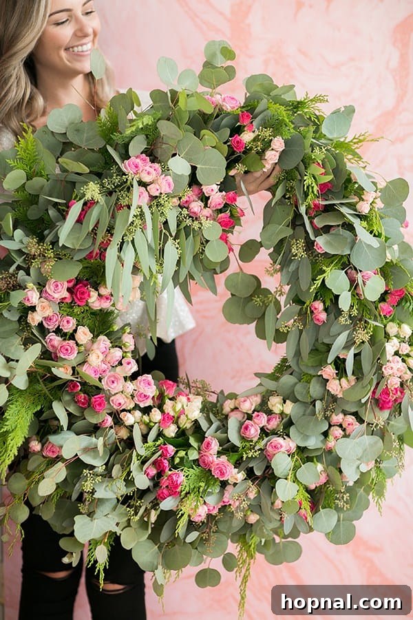 Greenery and Good Times Wreath Party 10 Guest proudly holding up a beautifully crafted, personalized holiday wreath they made