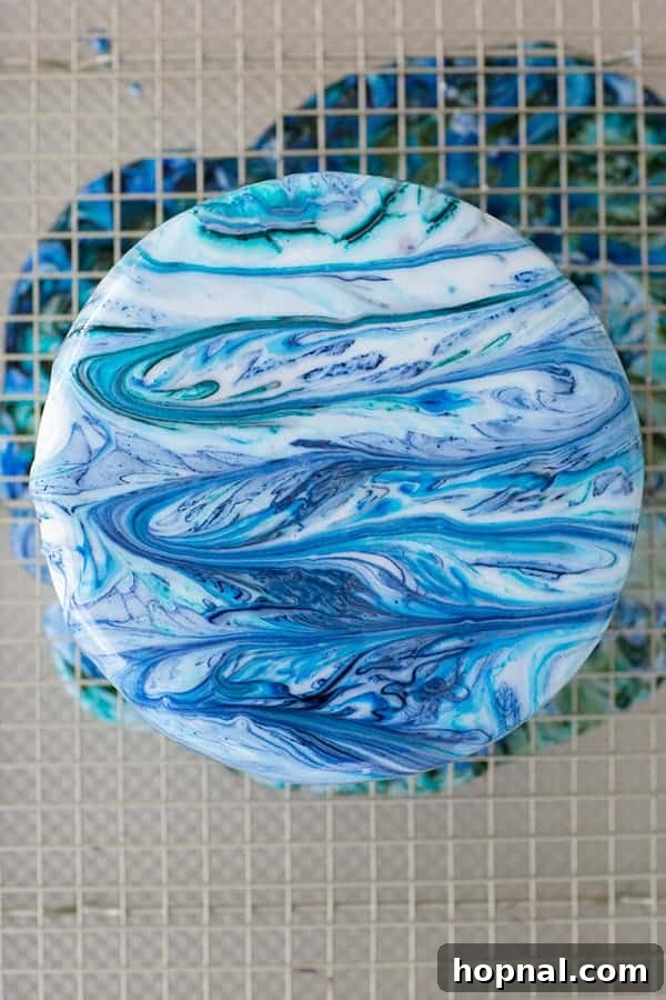 A cake with a vibrant, beautifully marbled drip effect on its sides, showcasing blended colors.