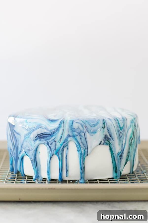 A stunning marble drip cake, beautifully decorated and presented on a serving tray.